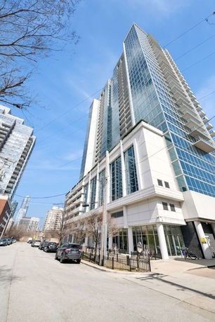 Exterior view of a tall modern apartment building with glass facades.