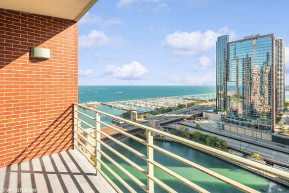 Panoramic view from a balcony overlooking a marina and high-rise buildings.
