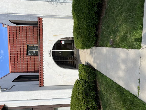 Front view of a building with an arched entrance and red-tiled roof.
