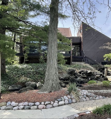 Front view of a modern house with large windows and an angular roof design.