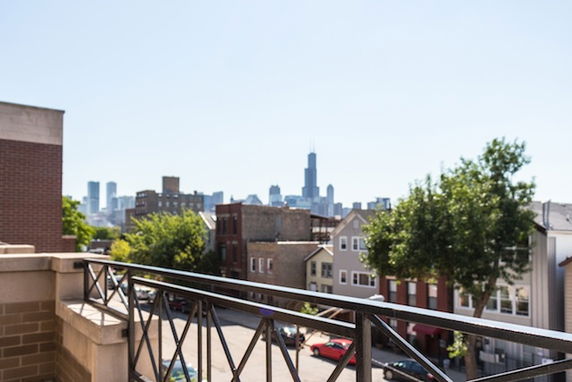 Panoramic view looking out from a building, showing a cityscape with several buildings in the background.