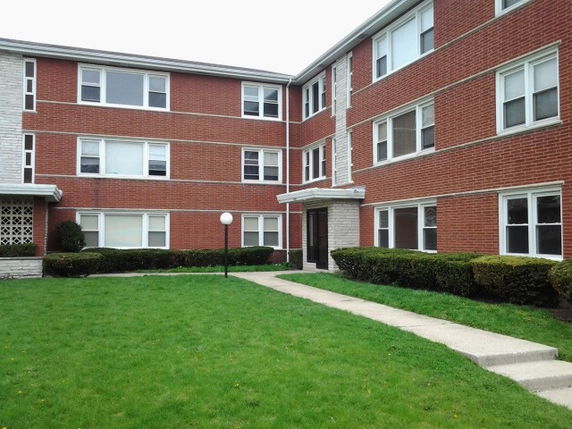 Front view of a three-story brick apartment building.