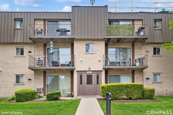 Front view of a three-story apartment building with balconies.