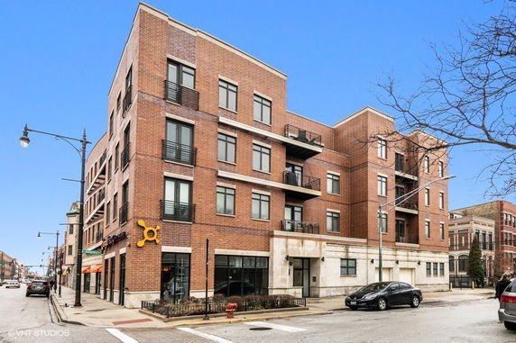 Front view of a multi-story brick building with balconies.