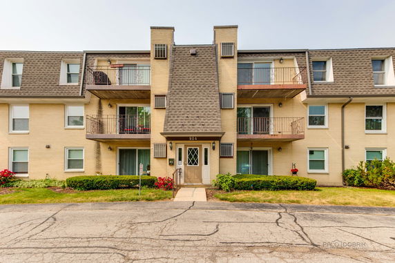 Front view of a three-story building with balconies on the upper floors.