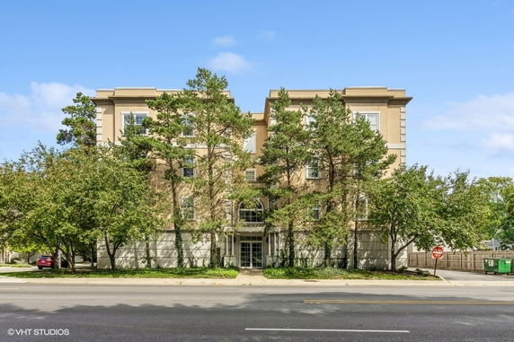Front view of a multi-story building with trees in front.