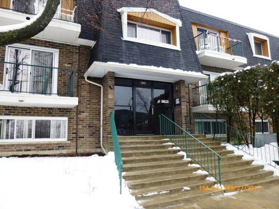 Front view of a multi-story building with steps leading to the entrance.