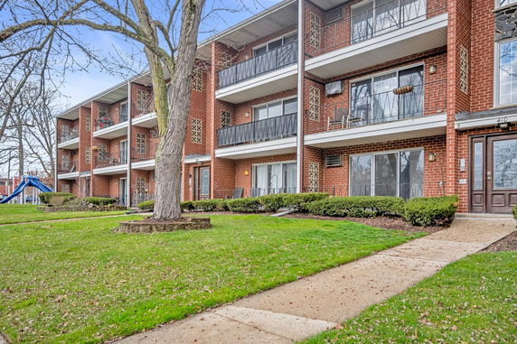Front view of a multi-story apartment building with balconies.