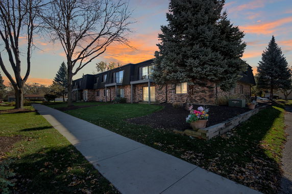 Front view of a multi-story townhouse with a brick exterior and balcony areas.