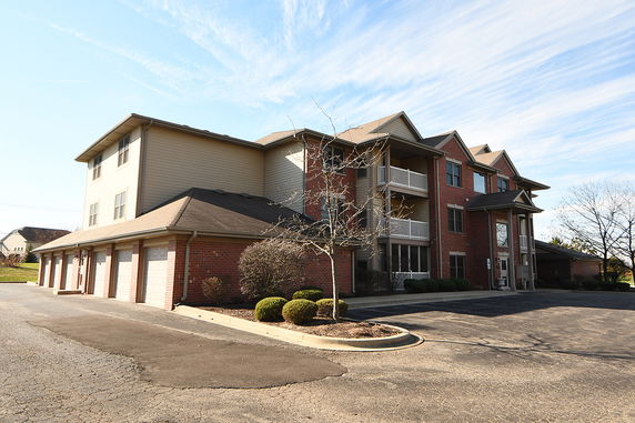 Front view of a two-story brick apartment building with attached garages.