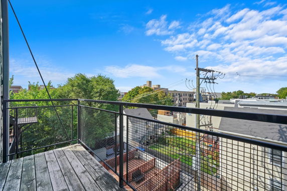 View from a balcony showing surrounding buildings and trees.
