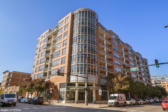 Front view of a multi-story building with large glass windows and balconies.