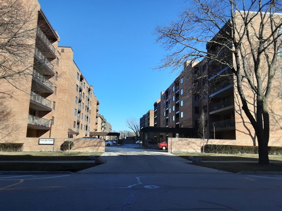Front view of multi-story brick apartment buildings with balconies.