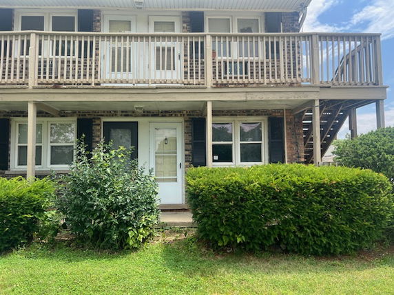 Front view of a two-story house with upper balcony and staircase.