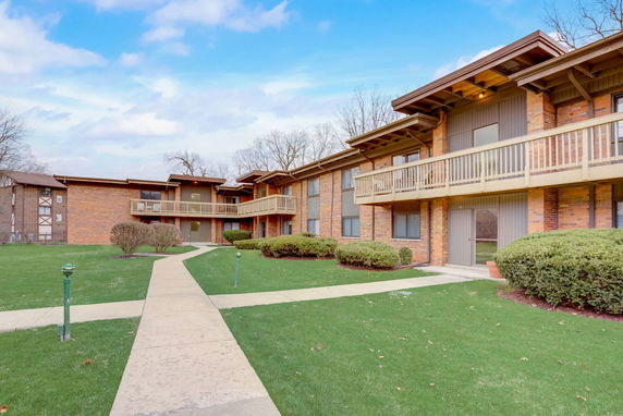 Front view of an apartment building with balconies and pathways.