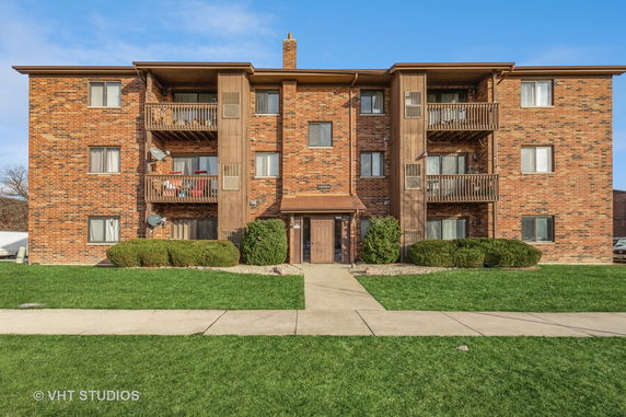 Front view of a three-story brick apartment building.