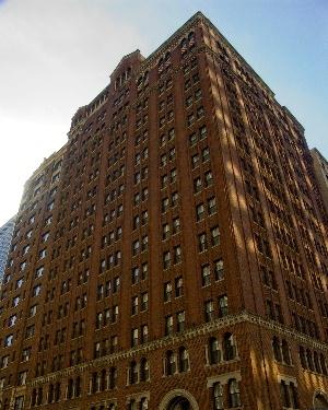 Front view of a tall brick building with numerous windows.