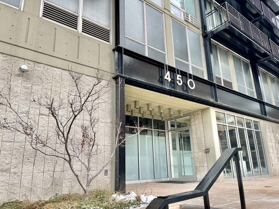 Front view of a modern building with large windows and visible unit number.