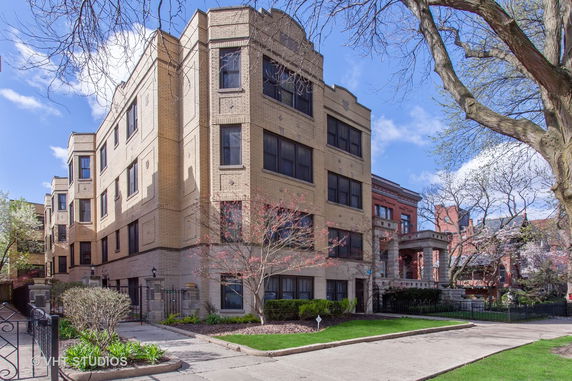 Front view of a multi-story brick building with large windows.