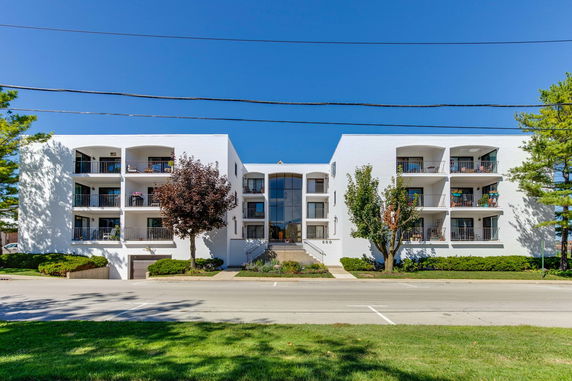 Front view of a modern multi-story apartment building with balconies.
