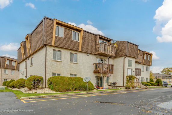Front view of a multi-story apartment building with balconies.