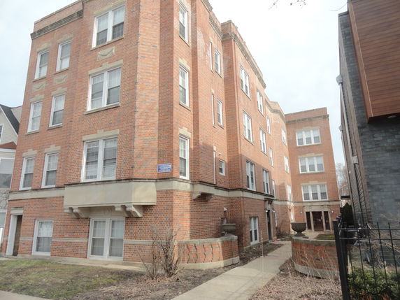 Front view of a multi-story brick apartment building.