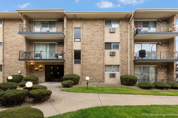 Front view of a three-story apartment building with balconies.