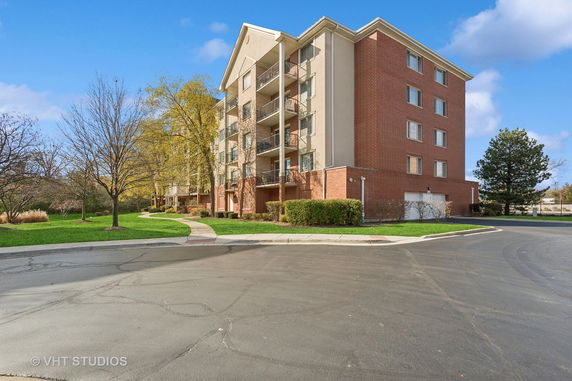 Front view of a multi-story residential building with brick facade and balconies.