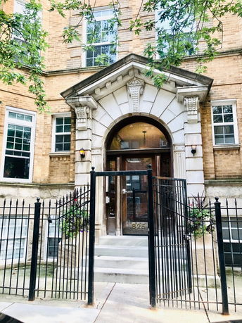 Front view of a brick building with a decorative entrance.