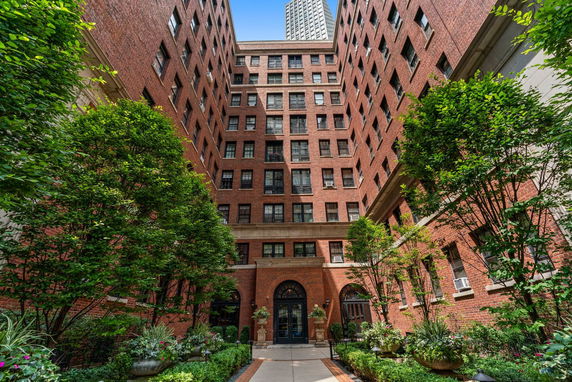Front view of a multi-story brick building with an archway entrance.