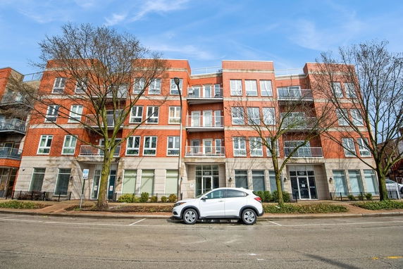 Front view of a multi-story brick apartment building with balconies.
