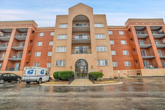 Front view of a multi-story residential building with balconies.
