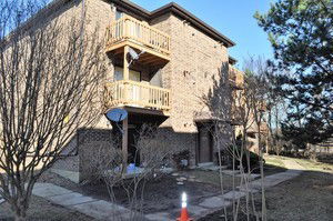 Front view of a multi-story brick apartment building with balconies.