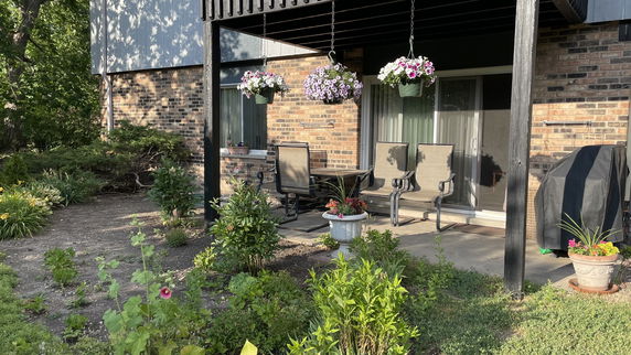 Front view of a house with a patio and potted flowers.