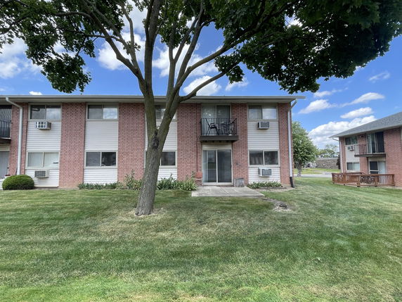 Front view of a two-story apartment building with brick and siding exterior.