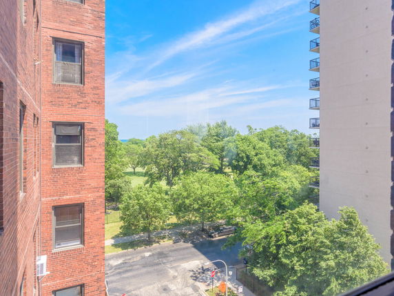 View from a building showing surrounding trees and nearby buildings.