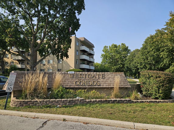 Front view of a multi-story condominium building with balconies.