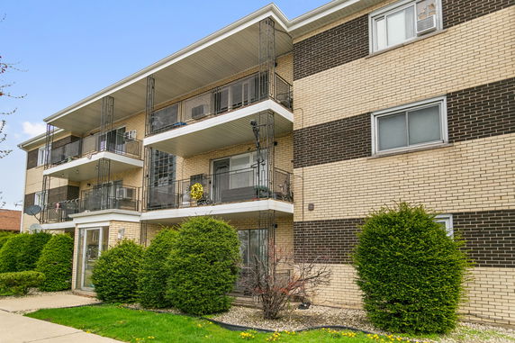 Front view of a three-story apartment building with balconies.