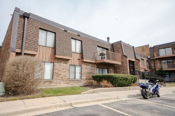 Front view of a two-story brick apartment building with balconies.