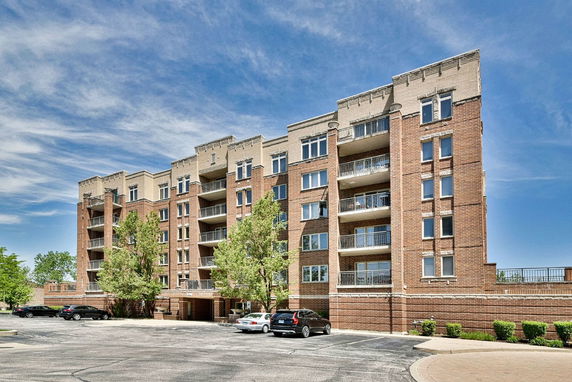 Front view of a multi-story brick apartment building with balconies.