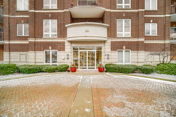 Front view of a multi-story brick building with glass entrance doors.