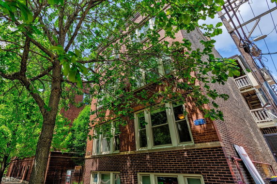 Front view of a multi-story brick building with multiple windows.