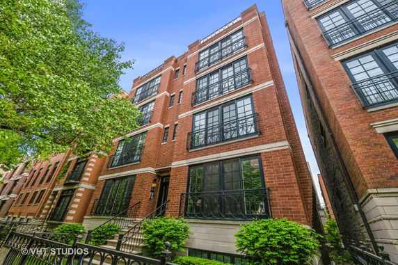 Front view of a multi-story brick building with large windows.