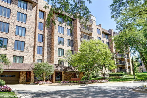 Front view of a multi-story brick apartment building with balconies.