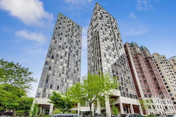Front view of two high-rise residential buildings with glass facades.