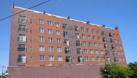 Front view of a multi-story brick apartment building.