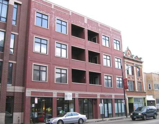 Front view of a multi-story brick building with large windows.