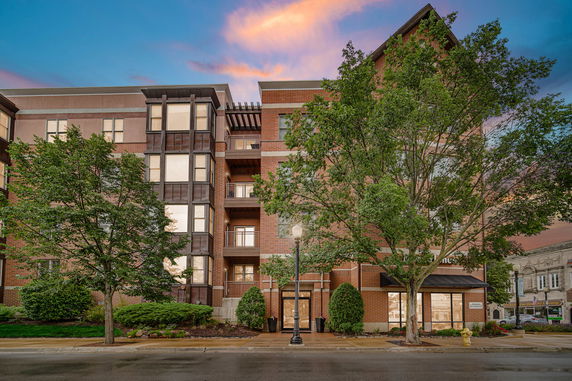 Front view of a multi-story brick building with large windows and balconies.