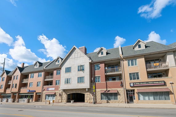 Front view of a multi-story building with commercial spaces on the ground floor.