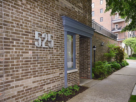 Front view of a brick building with large numbers and a small awning over an entrance.